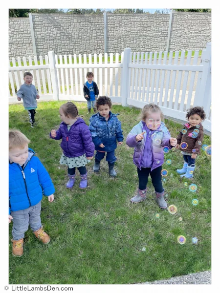 Children playing with bubbles in backyard daycare setting little lambs den bremerton wa